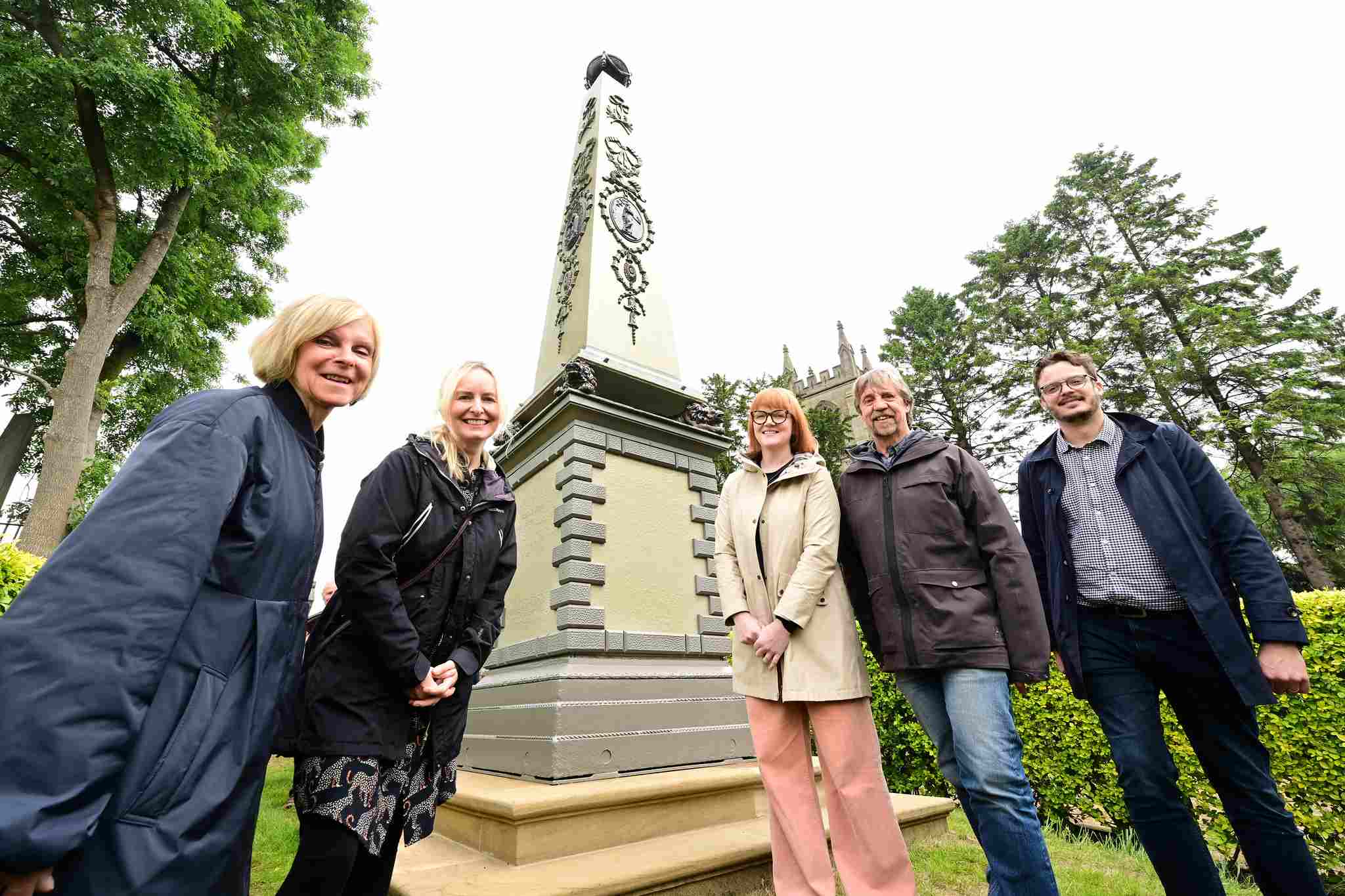 Members of project team in front of obelisk