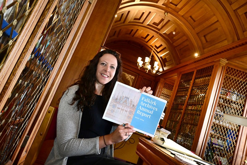 Woman holding document in wood panelled room